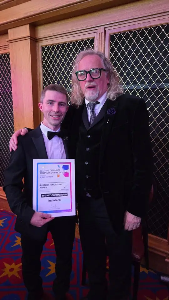 Two people at an awards evening, one holding a certificate