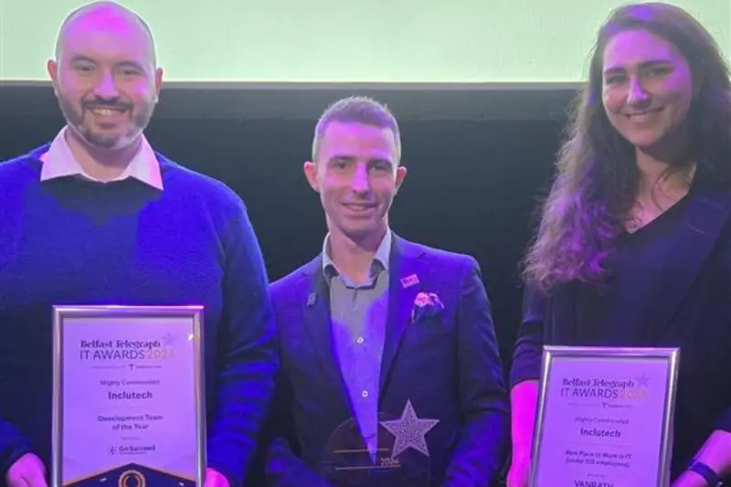 Three people on stage holding Belfast Telegraph IT Awards certificates for Inclutech