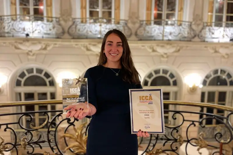 Holding an ICCA award and certificate in an ornate ballroom