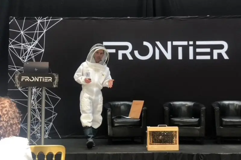 A speaker in a beekeeping suit on the Frontier stage